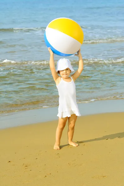蹒跚学步女孩在海滩上玩她充气球 — 图库照片