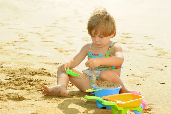 Happy toddler girl playing with her toys at beach — Stock Photo, Image