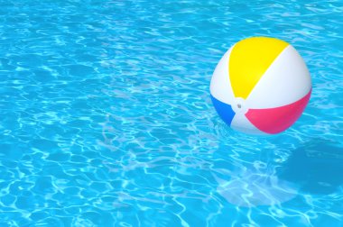 Inflatable ball floating in swimming pool clipart