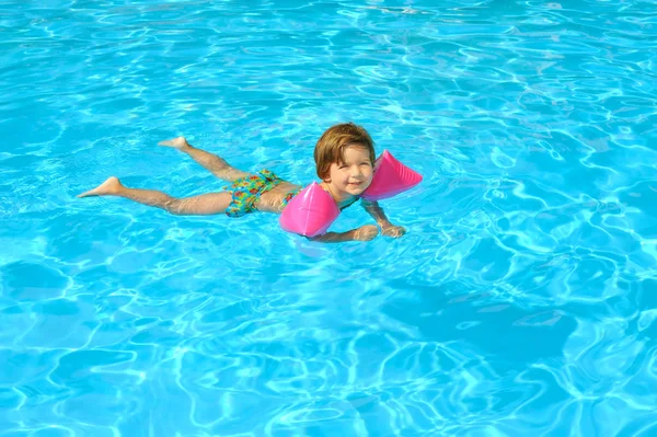 Menina aprendendo a nadar na piscina — Fotografia de Stock