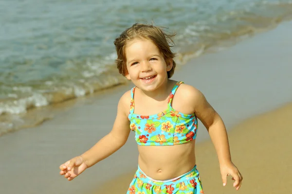 Peuter meisje uitgevoerd op strand — Stockfoto