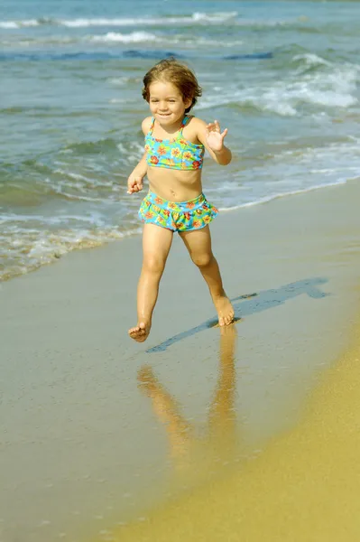 幼児の女の子がビーチで実行しています。 — ストック写真