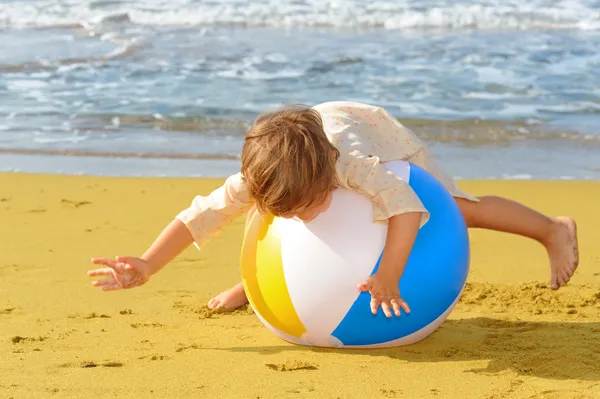 Niña jugando con su pelota inflable en la playa —  Fotos de Stock