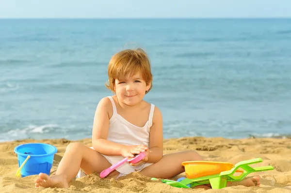 Happy toddler girl playing with her toys at beach — Stock Photo, Image