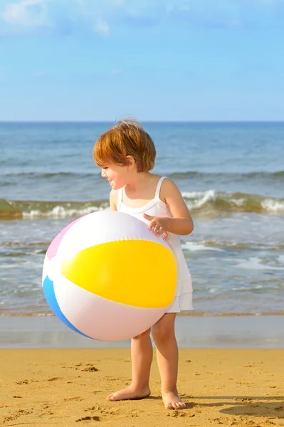 Toddler girl playing with her inflatable ball at beach — Stock Photo, Image