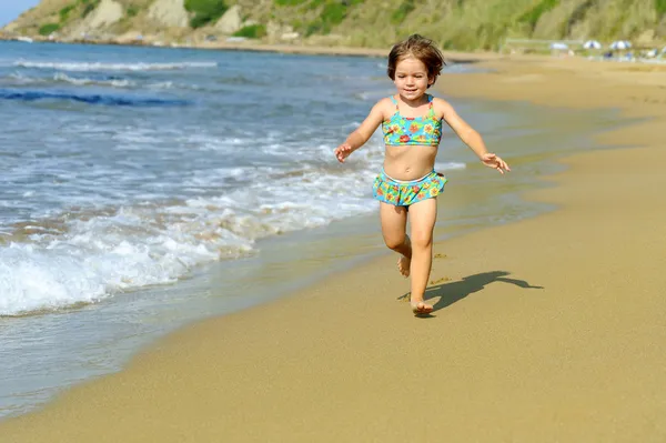 Happy toddler girl running at beach — Stock Photo, Image