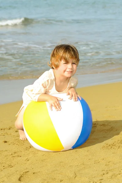 快乐蹒跚学步女孩在海滩上玩她多彩的球 — 图库照片
