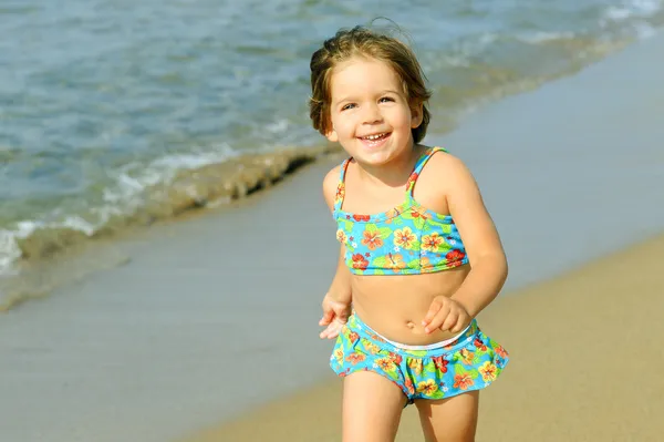 Счастливая девочка бегает на пляже — стоковое фото