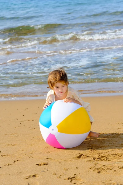幸せな幼児の女の子がビーチで彼女のカラフルなボールで遊ぶ — ストック写真