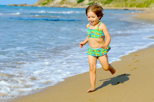 幸せな幼児の女の子がビーチで実行されています。 — ストック写真