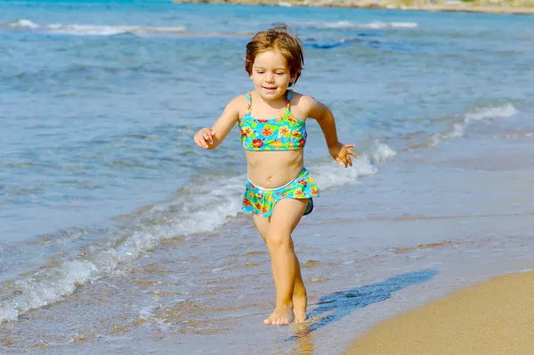 Happy toddler girl running on the beach — Stock Photo, Image