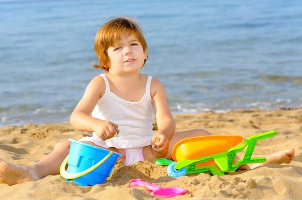 Happy toddler girl playing with her toys at beach — Stock Photo, Image