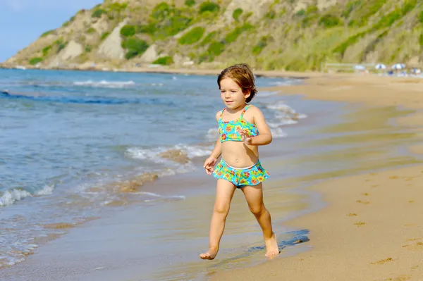 Happy toddler girl running on the beach — Stock Photo, Image