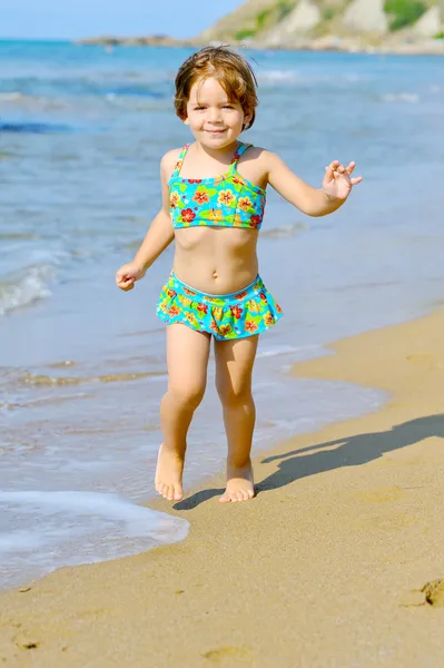 Feliz niña corriendo en la playa — Foto de Stock