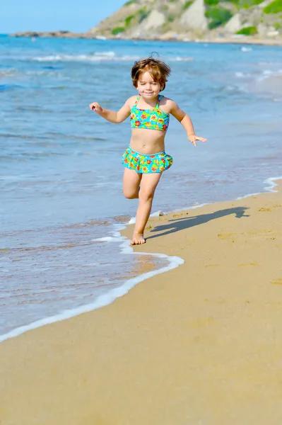 Feliz niña corriendo en la playa — Foto de Stock