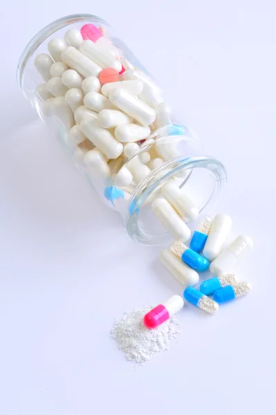 Multi colored capsules spilling from a bottle — Stock Photo, Image