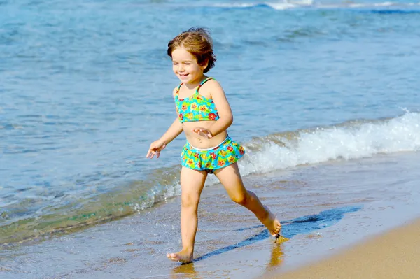 Happy toddler girl running on the beach — Stock Photo, Image