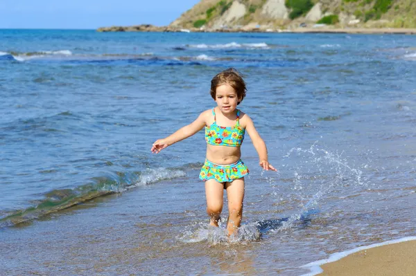 快乐蹒跚学步女孩在海滩上运行 — 图库照片