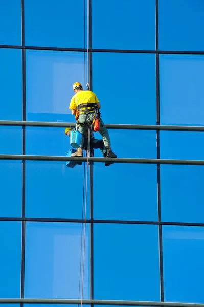 Laveuse laver les fenêtres du gratte-ciel moderne — Photo