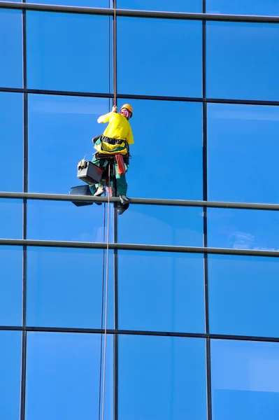 Washer wash the windows of modern skyscraper — Stock Photo, Image