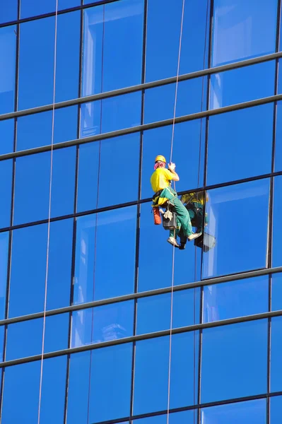 Laveuse laver les fenêtres du gratte-ciel moderne — Photo