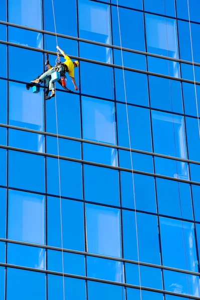 Washer wash the windows of modern skyscraper — Stock Photo, Image