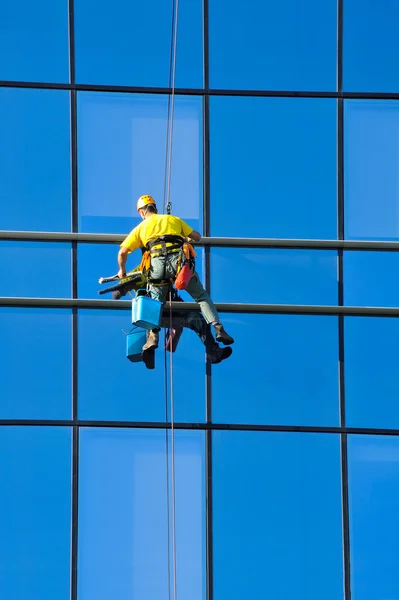 Laveuse laver les fenêtres du gratte-ciel moderne — Photo