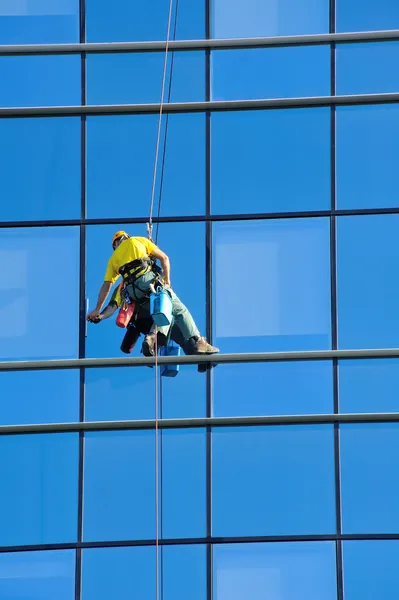 Washer wash the windows of modern skyscraper — Stock Photo, Image