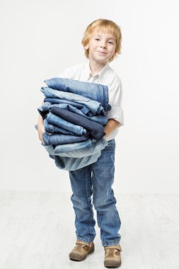Child holding jeans stack. Kids clothing fashion. White backgrou clipart