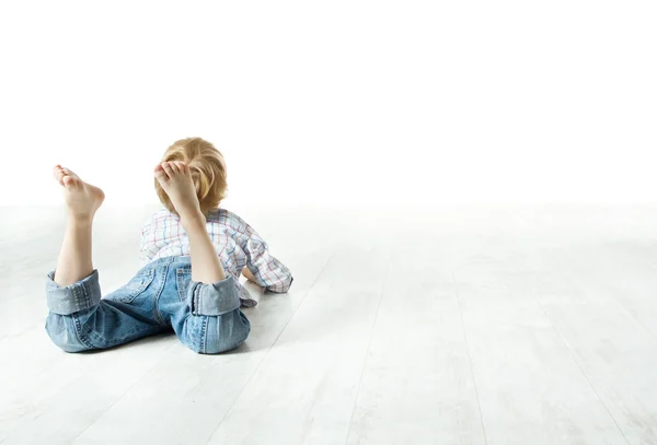 Kind terug op verdieping liggen en kijken ernaar uit — Stockfoto