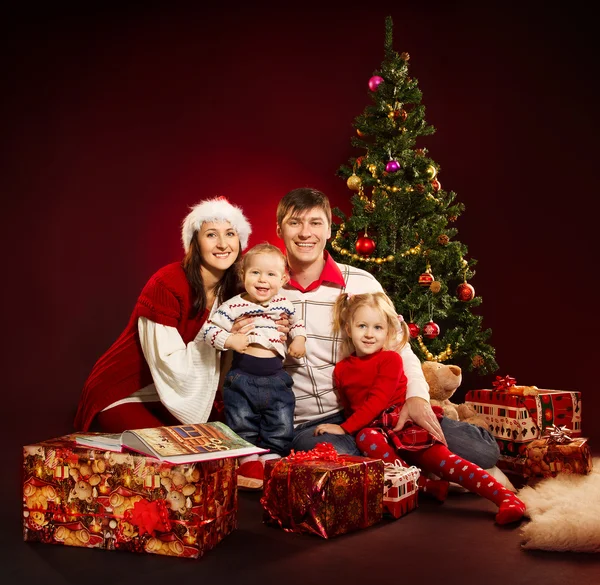 dört kişi ve köknar ağacı hediye kutuları ile Noel ailesi