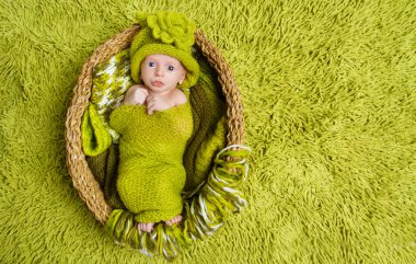 Yeni doğan bebek üzerinde yeşil renkli yün şapkalı