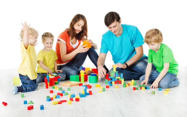 Ευτυχισμένη οικογένεια. Οι γονείς με τρία παιδιά που παίζουν παιχνίδια μπλοκ — Φωτογραφία Αρχείου