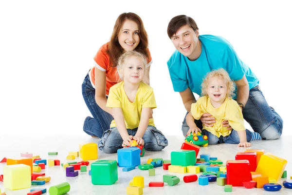 Familia feliz. Padres con tres hijos jugando bloques de juguetes —  Fotos de Stock