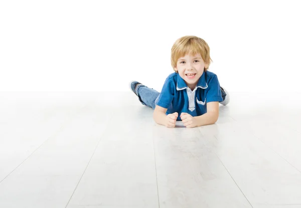Leende liten pojke liggande på golvet — Stockfoto