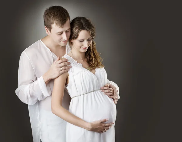 Pregnant woman with husband looking on belly — Stock Photo, Image