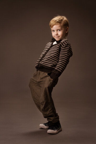 Boy over brown background. Vintage style. Kids fas