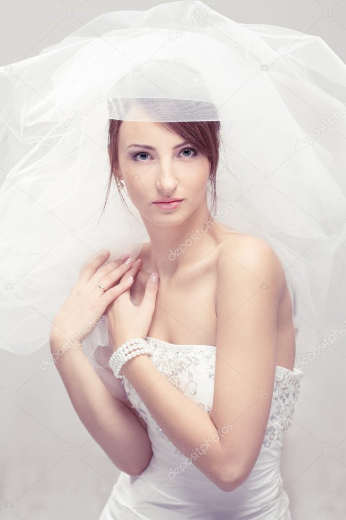 Bride in white veil looking at camera. Portrait. Fashion wedding