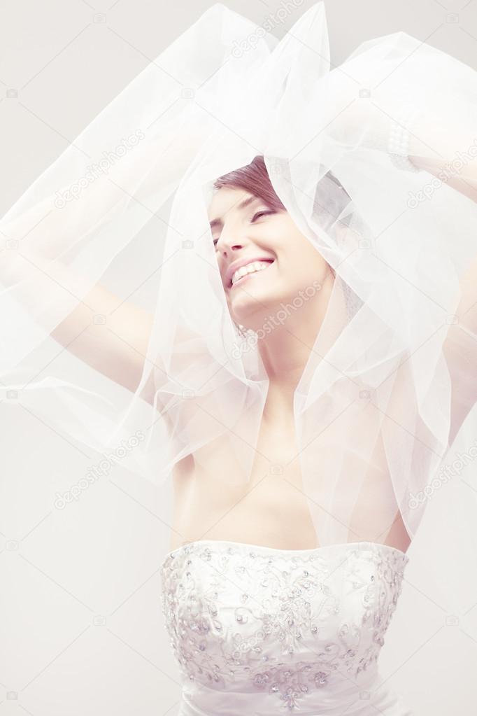 Happy bride smiling, closed eyes, carefree dreaming. Over white