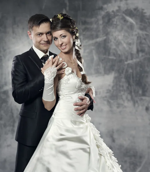 Wedding couple, bride and groom over gray grunge background — Stock Photo, Image