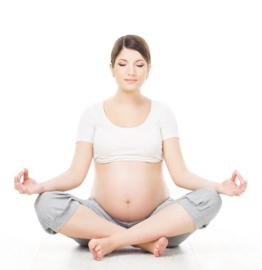 hamile kadın relax yoga yaparken, lotus pozisyonu üzerinde oturuyor.