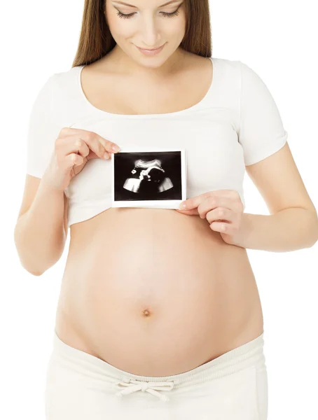 Pregnant woman holding ultrasound scan photo of baby over belly — Stock Photo, Image
