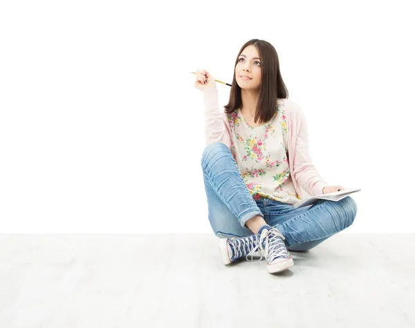 Beautiful girl teenager thinking sitting on floor. — Stock Photo, Image