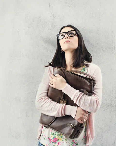 Thoughtful woman in eyeglasses holding bag. Sad expression — Stock Photo, Image