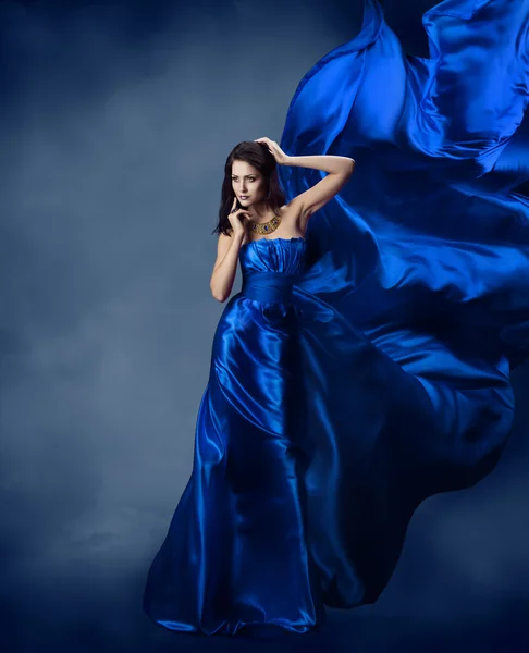 Frau in blauem Kleid mit fliegendem blauen Seidenstoff — Stockfoto