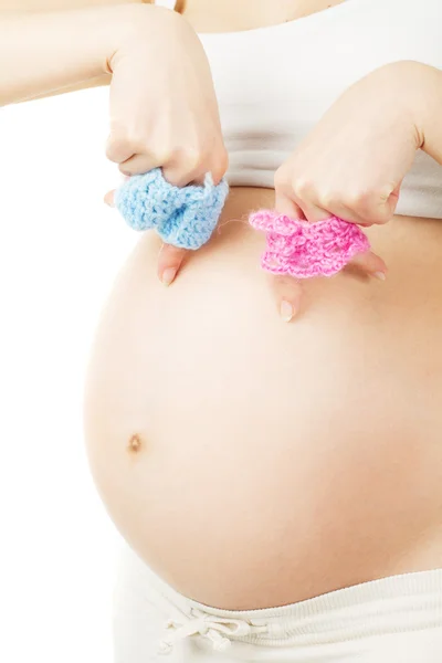 妊娠中の女性は、男の子と女の子の服を保持しています。新生児 b を期待してください。 — ストック写真