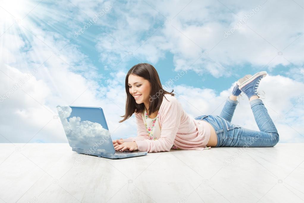 Girl using wireless laptop over sky background. Woman Typing in