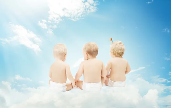 Bébés amis en couches assis sur des nuages sur fond de ciel. H — Photo