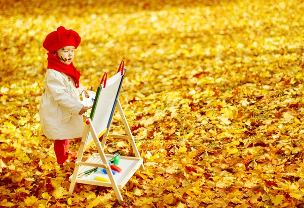 Niña de otoño dibujando en el parque de hojas de otoño, pintura para niños —  Fotos de Stock