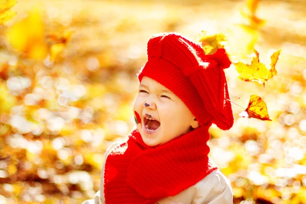 Glücklich lächelndes Kind im herbstlichen Park bei strahlendem Sonnenschein — Stockfoto